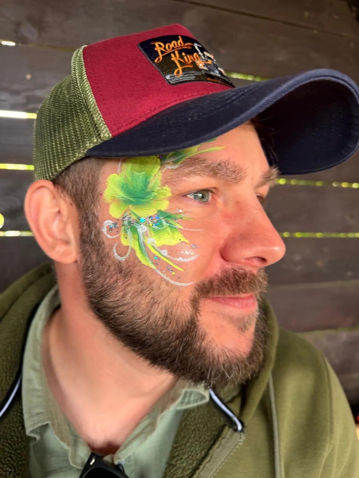 Facepainting mit Glitzer und Steinen im Gesicht eines Erwachsenen